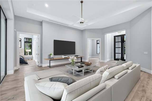 living room featuring light hardwood / wood-style flooring, french doors, and ceiling fan