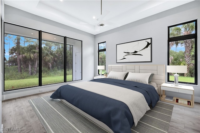 bedroom featuring multiple windows and light hardwood / wood-style floors