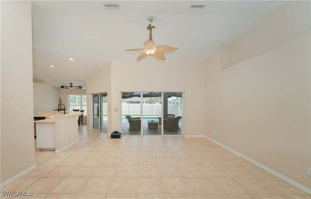 unfurnished room with ceiling fan, high vaulted ceiling, sink, and light tile patterned floors