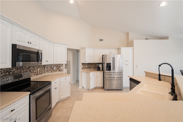 kitchen featuring tasteful backsplash, white cabinetry, light tile patterned flooring, sink, and stainless steel appliances