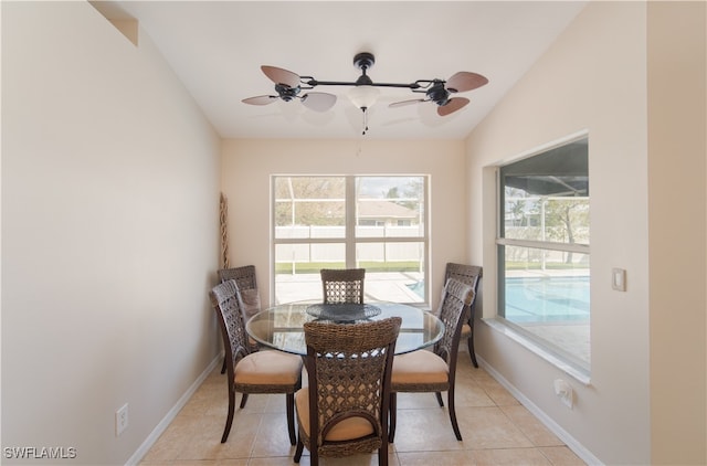 dining area featuring vaulted ceiling, light tile patterned flooring, and ceiling fan