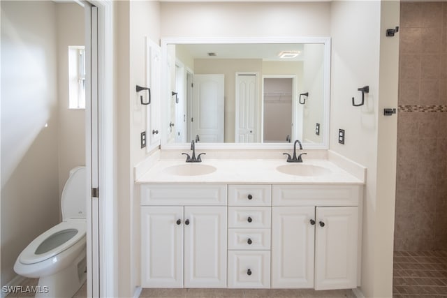 bathroom featuring vanity, toilet, and a tile shower