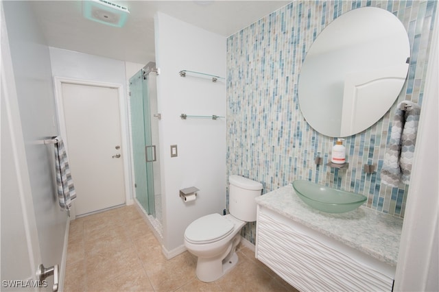 bathroom featuring vanity, toilet, tile patterned flooring, and an enclosed shower