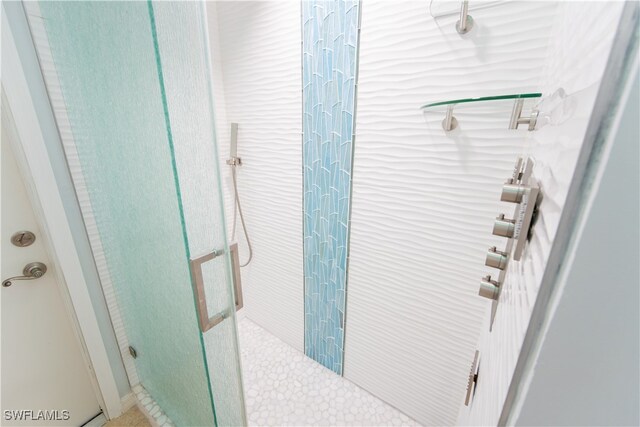 bathroom with a shower with door