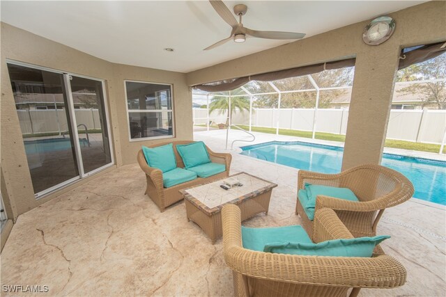 view of pool featuring a patio area, ceiling fan, and glass enclosure