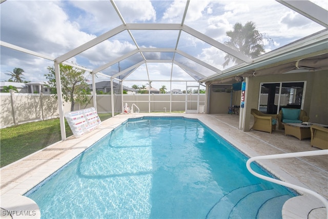 view of pool with a patio and glass enclosure