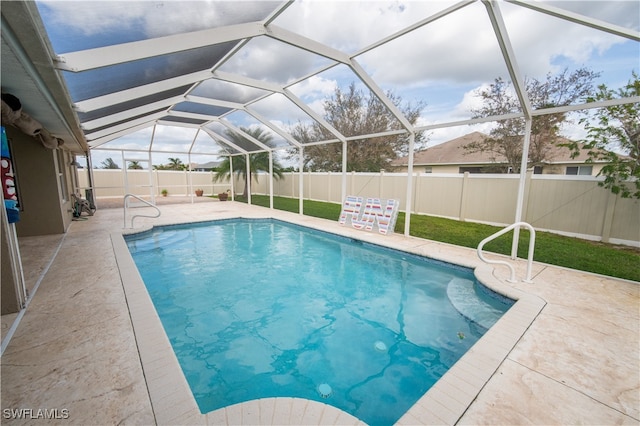 view of swimming pool with a patio area and glass enclosure