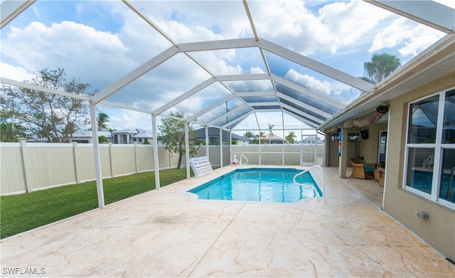 view of swimming pool with a patio area, a yard, and glass enclosure