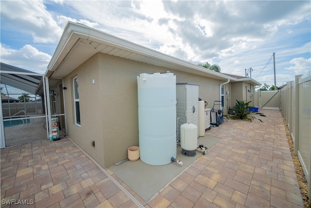 view of property exterior with a patio area and glass enclosure