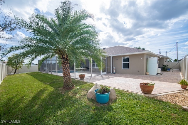 back of house with a patio, a lawn, a fenced in pool, and a lanai