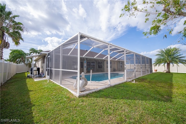 view of pool featuring a yard, a patio, and glass enclosure