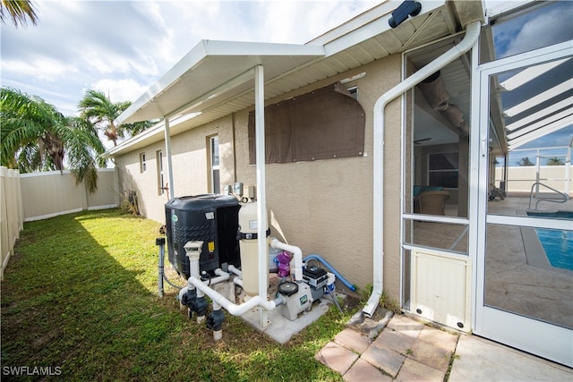 view of side of home featuring a yard, central air condition unit, and a patio area