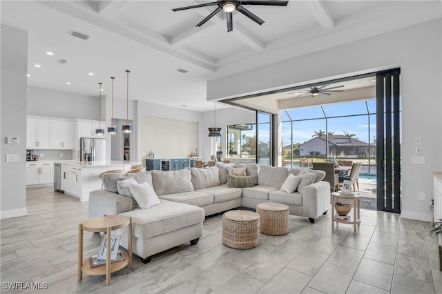 living room with beam ceiling, coffered ceiling, sink, and ceiling fan