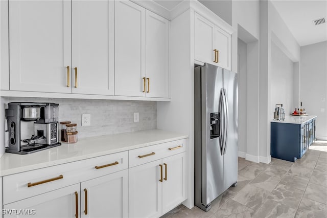 kitchen with white cabinetry, stainless steel refrigerator with ice dispenser, tasteful backsplash, and light stone counters