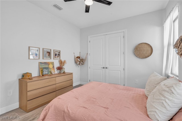 bedroom with a closet, light wood-type flooring, and ceiling fan