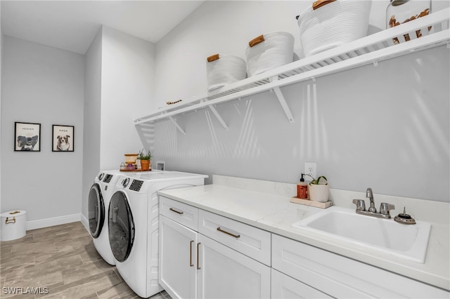 laundry area with cabinets, sink, washing machine and dryer, and light wood-type flooring