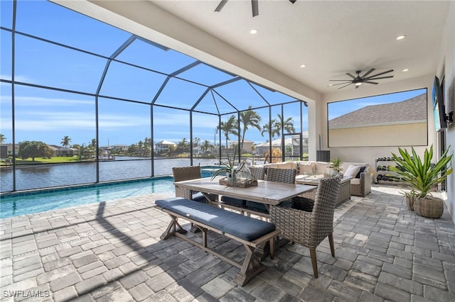 view of patio featuring an outdoor living space, a lanai, a water view, and ceiling fan