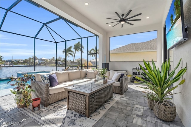 view of patio / terrace with glass enclosure, ceiling fan, a water view, and an outdoor hangout area