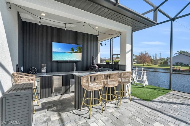 view of patio featuring wine cooler, an outdoor bar, and a lanai