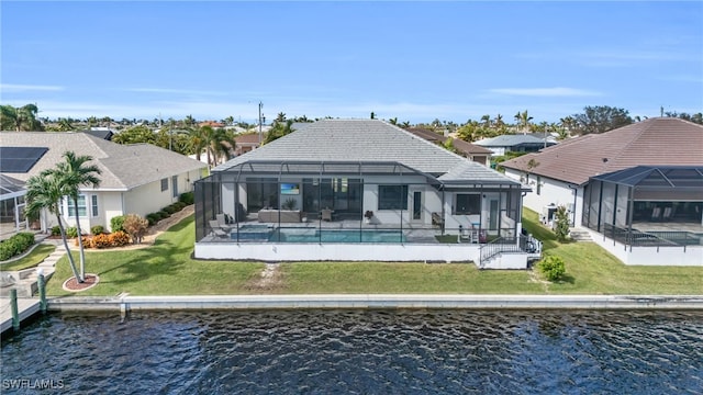 rear view of property featuring a patio, a lanai, a yard, and a water view