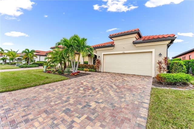 mediterranean / spanish-style house featuring a garage and a front lawn