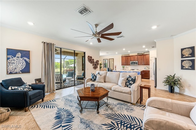 living room with light tile patterned floors, ornamental molding, and ceiling fan