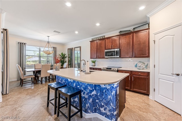 kitchen with sink, backsplash, stainless steel appliances, ornamental molding, and a center island with sink