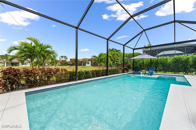 outdoor pool featuring glass enclosure and a patio