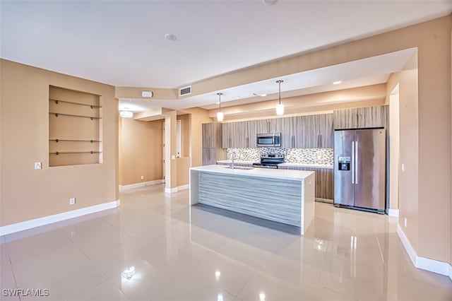 kitchen with decorative backsplash, light tile patterned flooring, hanging light fixtures, and stainless steel appliances