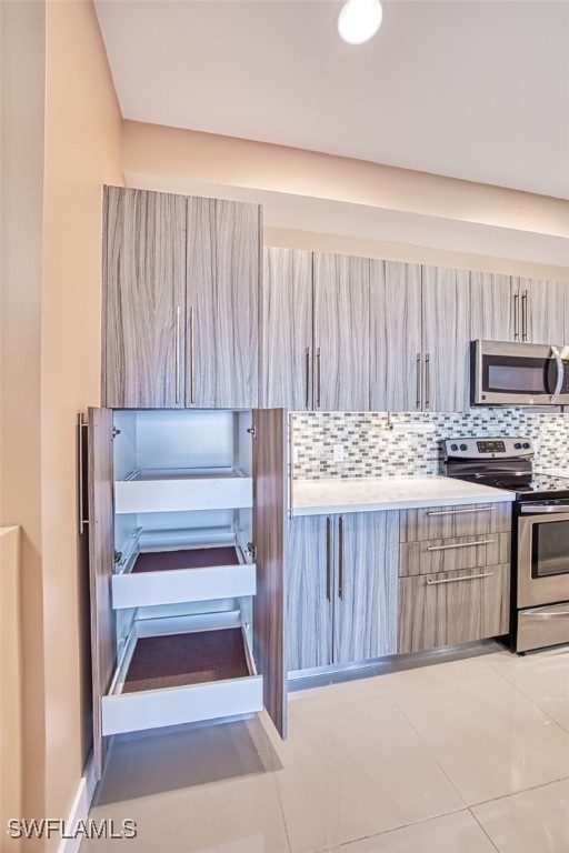 interior space featuring light brown cabinets, tasteful backsplash, stainless steel appliances, and tile patterned flooring