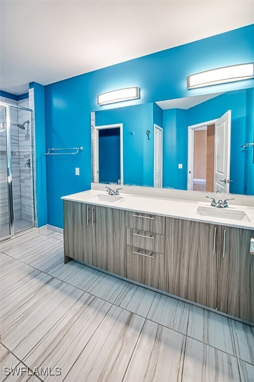11701 Olivetti Ln Unit 307, Fort Myers, FL 33908 - full bathroom featuring a sink, a shower stall, and double vanity