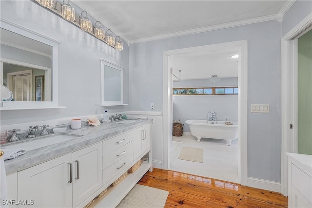 bathroom featuring crown molding, vanity, a bath, and wood-type flooring