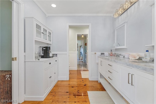 bathroom featuring vanity, hardwood / wood-style flooring, and crown molding