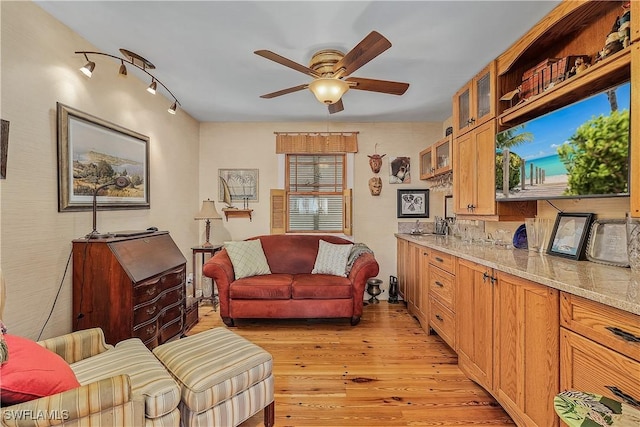 living room with ceiling fan, track lighting, and light wood-type flooring