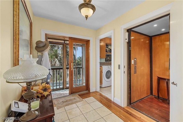 interior space with elevator, washer / dryer, and light hardwood / wood-style floors