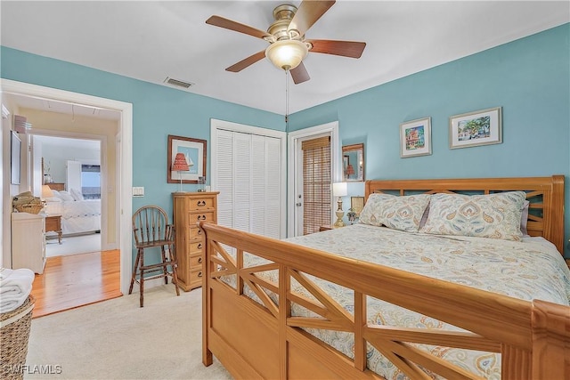 bedroom featuring light colored carpet, a closet, and ceiling fan