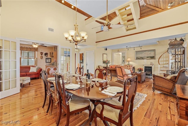 dining area featuring ceiling fan with notable chandelier and light hardwood / wood-style flooring