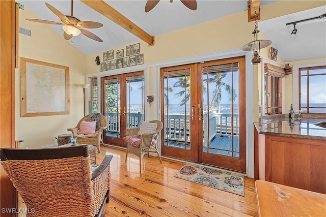 interior space featuring vaulted ceiling with beams, rail lighting, french doors, and light wood-type flooring