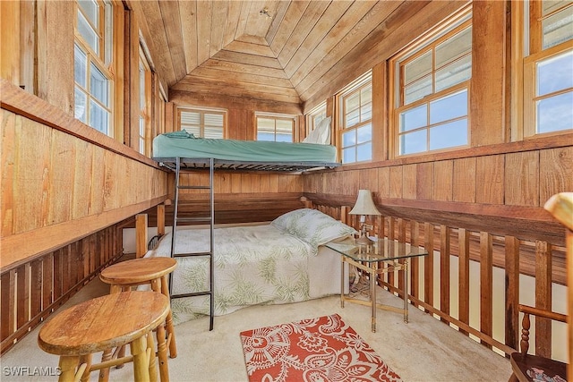 carpeted bedroom with vaulted ceiling, wooden ceiling, and wood walls