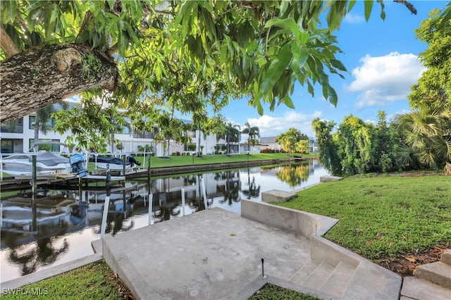 view of dock with a water view and a lawn