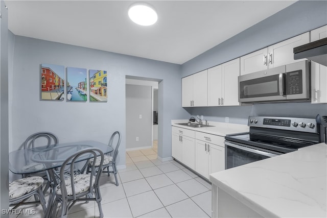 kitchen with white cabinetry, light tile patterned flooring, appliances with stainless steel finishes, and sink