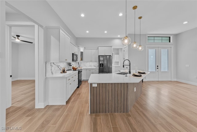 kitchen with light wood-type flooring, black electric range oven, decorative light fixtures, a center island with sink, and stainless steel refrigerator with ice dispenser