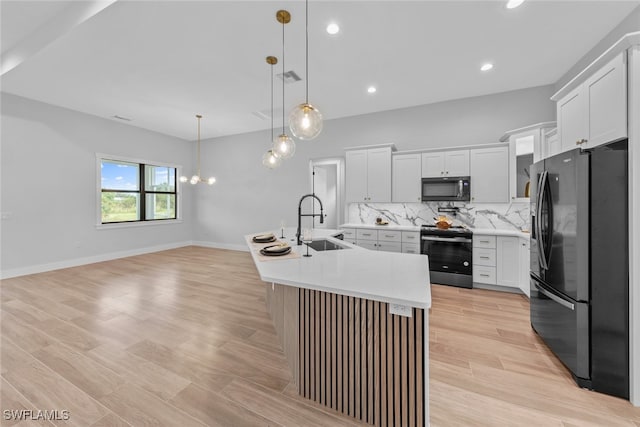 kitchen with refrigerator with ice dispenser, sink, electric range, white cabinetry, and a center island with sink