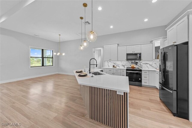 14081 Carlos St, Fort Myers, FL 33905 - kitchen featuring stainless steel appliances, light countertops, decorative backsplash, light wood-style floors, and hanging light fixtures