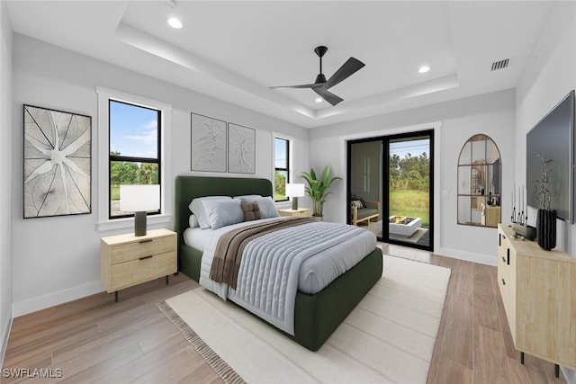 bedroom with light hardwood / wood-style flooring, multiple windows, and access to exterior