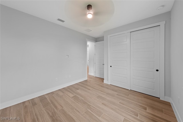 unfurnished bedroom featuring light hardwood / wood-style floors, a closet, and ceiling fan