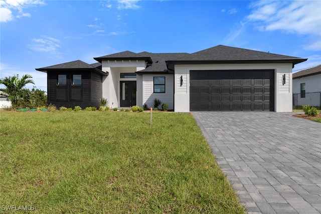 prairie-style home featuring a front yard and a garage