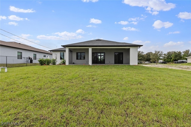 rear view of house featuring a yard