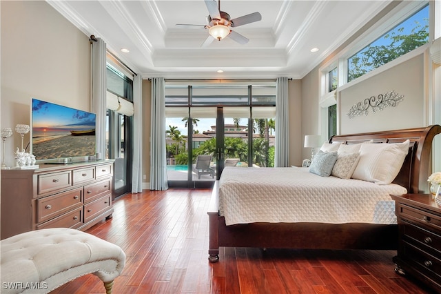 bedroom with ceiling fan, hardwood / wood-style floors, access to outside, a tray ceiling, and ornamental molding