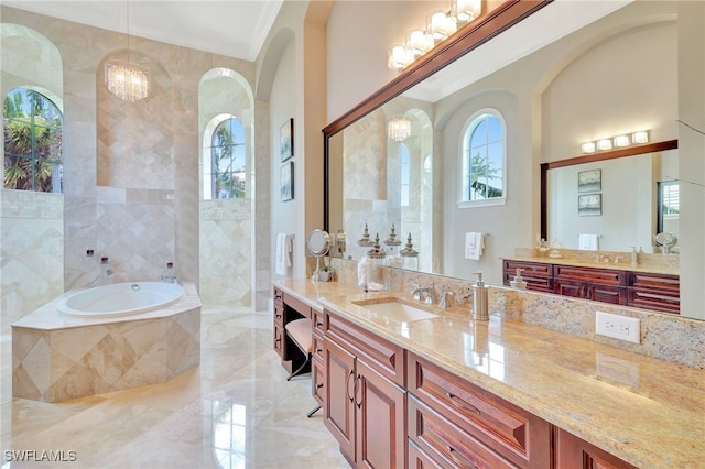 bathroom with a relaxing tiled tub, a notable chandelier, tile walls, crown molding, and vanity